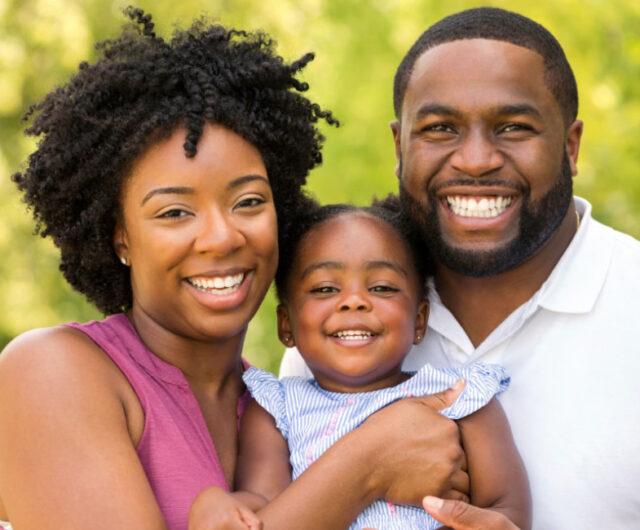 smiling parents holding their young child